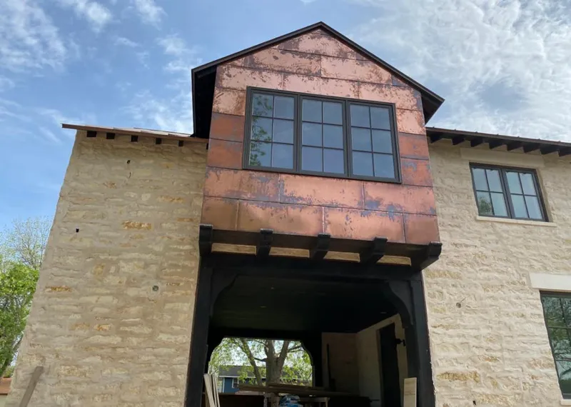 Copper metal panel facade on a stone building for Skylight Installation in Fergus Falls